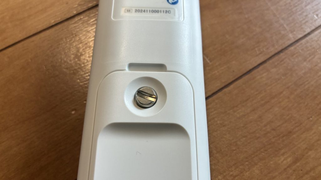 本体背面にある電池カバーのコイン式ネジのアップ