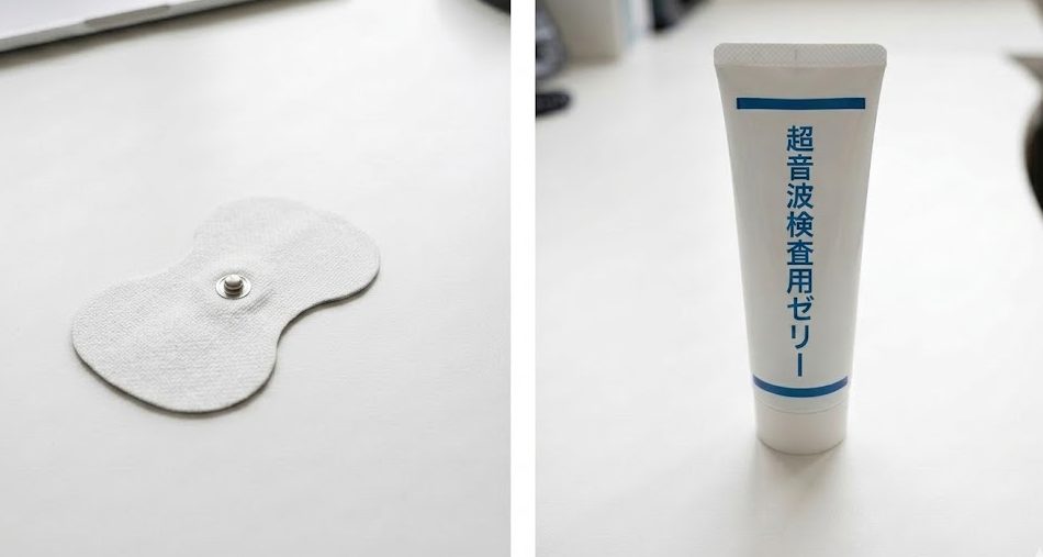 白いデスクの上に置かれたひょうたん型の低周波治療器用パッドと、超音波検査用ゼリーのチューブ