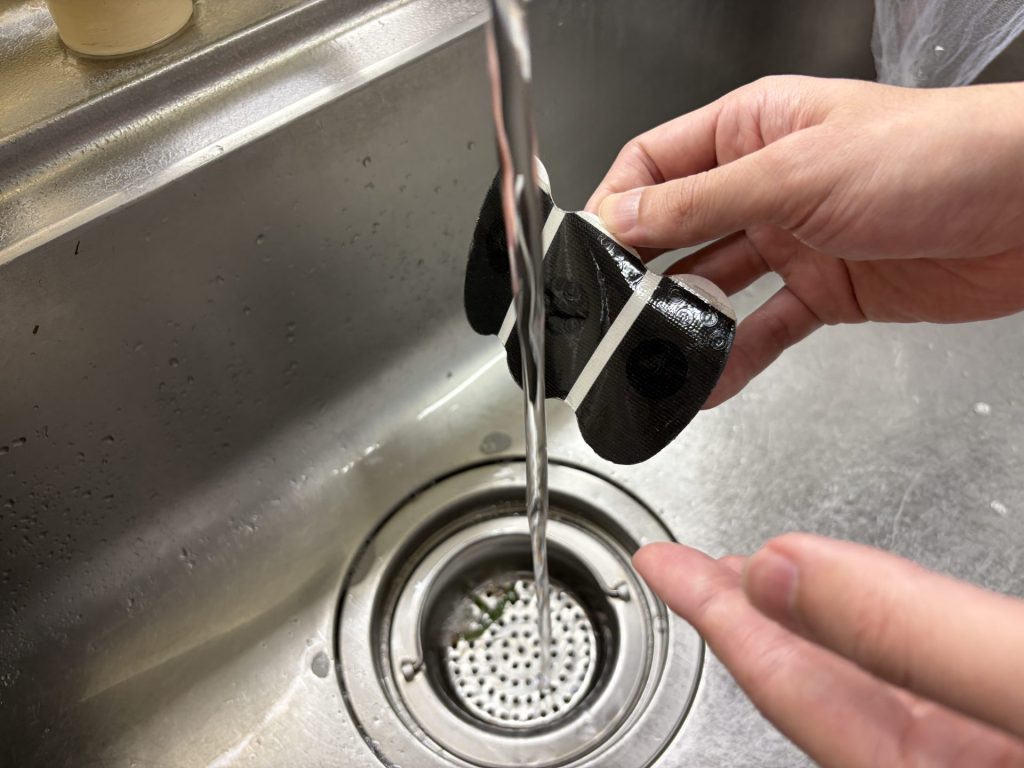 3Dパッドの粘着面を流水で洗っているところ