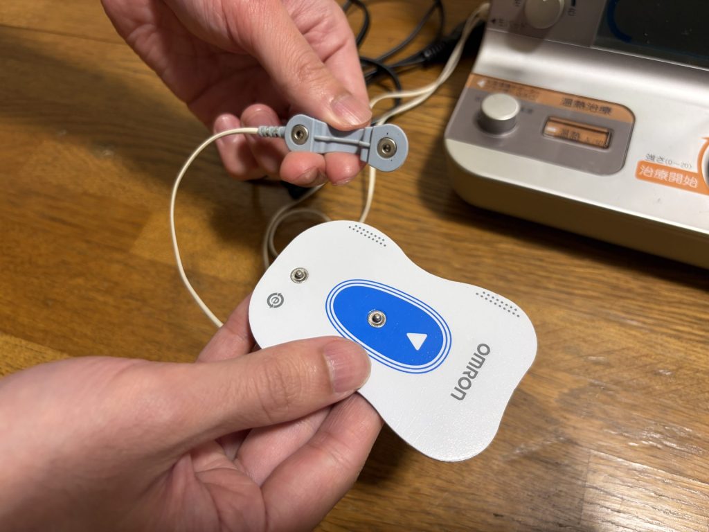 導子コードをオムロン患部集中パッドへ接続する様子
